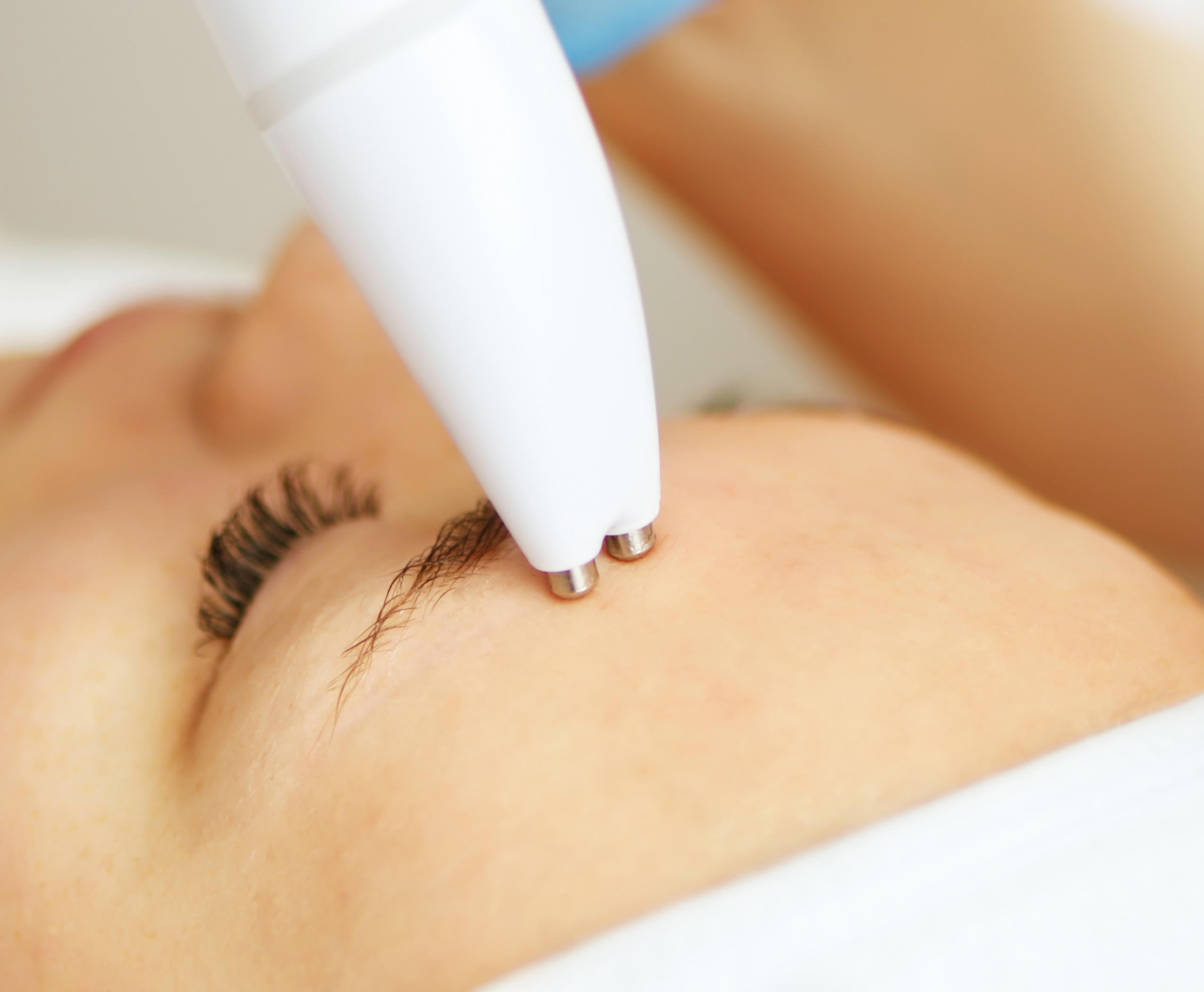 Close-up of a woman using a jade roller around her eye area during the UFO Anti-Wrinkle Eye Lift treatment.